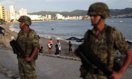 ‘Welcome to Acapulco’: soldiers stand guard near the resort’s main tourist beach.