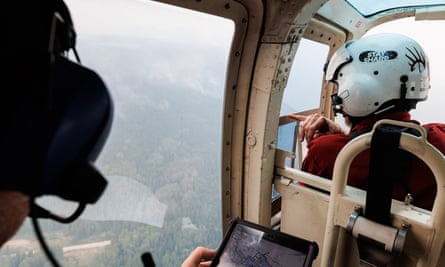 Wildfire ignitions trainee Morgan Boghean watches out the window of a helicopter as he and his mentor Mike Morrow map the perimeter of a wildfire outside Vanderhoof, British Columbia, Canada.