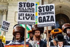 Orthodox Jewish men wearing shtreimels hold up placards that say ‘Stop killing journalists. Let Gaza live’ and ‘Stop starving Gaza’
