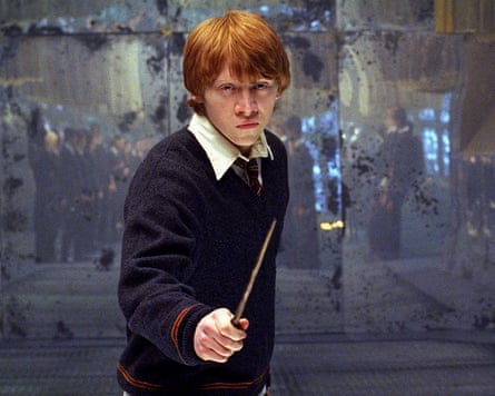 teen boy with collared shirt and sweater holds magic wand