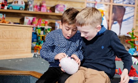 Two boys play with a Hatchimal.