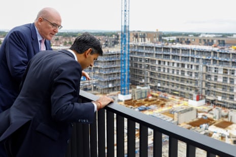 Rishi Sunak (right) with Barratt Developments’ regional managing director Gary Ennis on a balcony of a unit that is part of Hayes Village, in London, this morning.