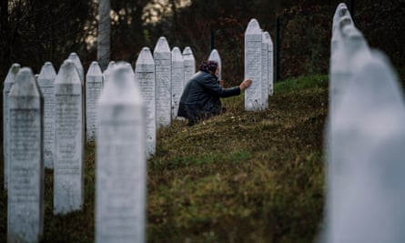 A Bosnian woman prays near a grave of her relative at the memorial centre of Potocari near Srebrenica