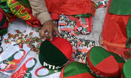 A Pakistan Tehreek-e-Insaf party activist sells PTI flags and caps near Khan’s home.
