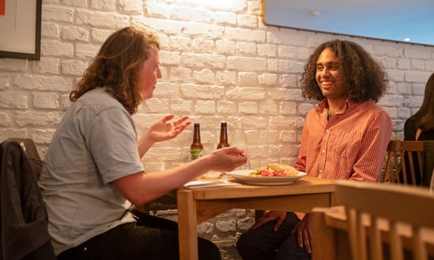 Dining across the divide: ‘He supports a new Heathrow runway – we should invest in trains’ 6 Jasper and Miles sitting at a restaurant table against a white-painted brick wall