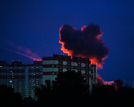 Smoke billows from a tall residential building at night