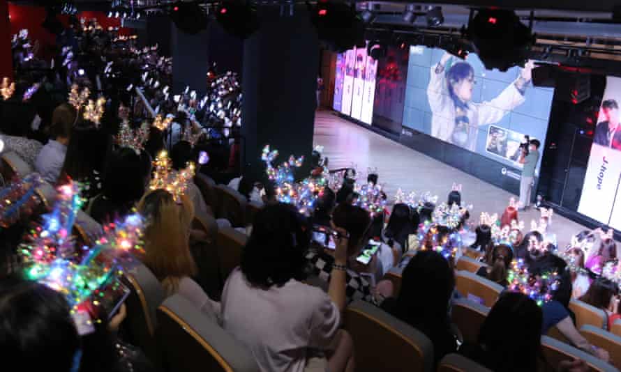 Fans of Chinese K-pop band BTS watch them perform at a Beijing festival in June