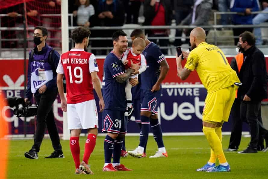 Il portiere del Reims Predrag Rajković chiede a Lionel Messi di tenere suo figlio per una foto.