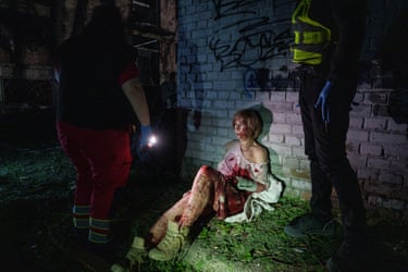 Valeria Syniuk sits against a building covered in blood
