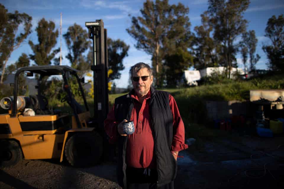 Graeme Freedman sips his coffee in front of the house he has rebuilt mostly himself in Wandella, near Cobargo on the NSW south coast