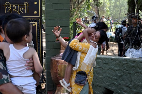 नेपाल के नुवाकोट जिले के त्रिशूली शिविर में बाढ़ स्थल से बचाए जाने के बाद एक महिला अपने बच्चे को गले लगाती हुई।