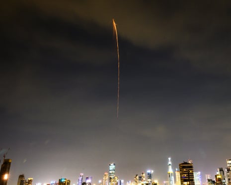 A projectile from an Iranian ballistic cluster munition falls from the sky over the skyline in Tel Aviv on Monday
