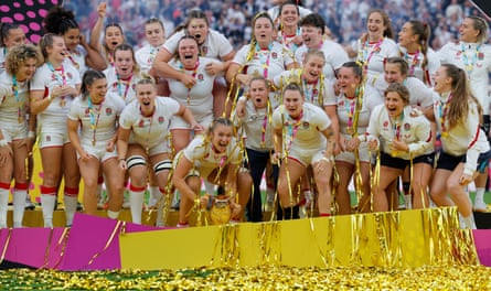 England’s Zoe Aldcroft holds the trophy as she celebrates with teammates.