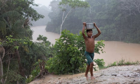 A young Marubo boy, Metsisi Marubo, carries water from the Rio Itui toward the village of Rio Novo