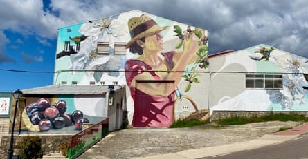 A mural on a wall of cherries and people picking them