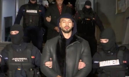 In this grab taken from video released by Observator Antena 1, Andrew Tate is being led away by police in Ilfov, Romania, on 29 December.