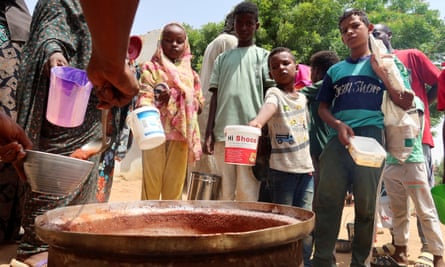 People holding pots as volunteers distributed food in Omdurman last September.