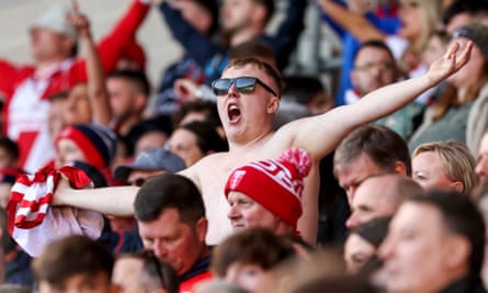 A Hull KR fan whips his shirt off in the stands