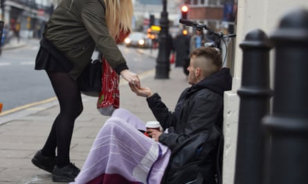 Jason Nash, who is homeless in Brighton, receives money from a stranger