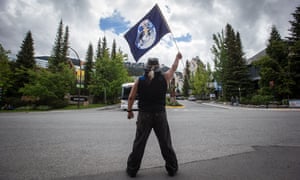 A demonstrator holds a flag with an image of Earth during a protest in British Columbia on 2 June 2018 against another Kinder Morgan Trans Mountain pipeline expansion.
