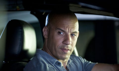 Vin Diesel stares narrow-eyed from the driver's seat.