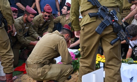 Fellow soldiers of Valentin (Eli)&nbsp;Ghnassia, 23, who was killed in a battle with Palestinian militants at Kibbutz Be’eeri near the Israeli border with the Gaza Strip, cry at his grave during his funeral on 12 October 2023 at Mount Herzl Military Cemetery in Jerusalem, Israel. 