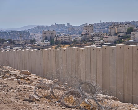 Concrete wall, barbed ligament connected crushed and buildings connected 1 side