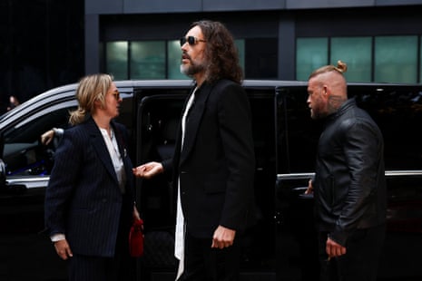 Russell Brand stepping out of his car with his wife outside court.