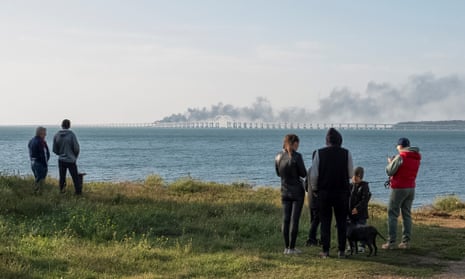 People watch smoke over the Kerch strait bridge between Russia and Crimea