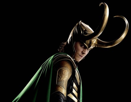Tom Hiddleston wearing a gold horned helmet, armour and a cloak as Loki in Avengers Assemble.