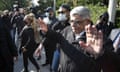 Nikos Michaloliakos waves to people on the street wearing masks