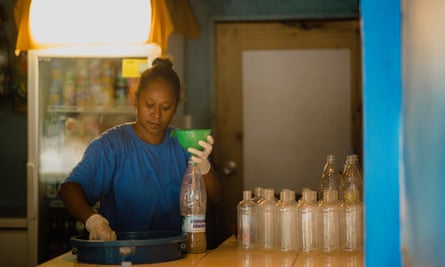 A staff member at Blue Galaxy nakamal, a kava bar in Port Vila, Vanuatu, fills plastic bottles with kava, due to Vanuatu’s Covid-19 restrictions.