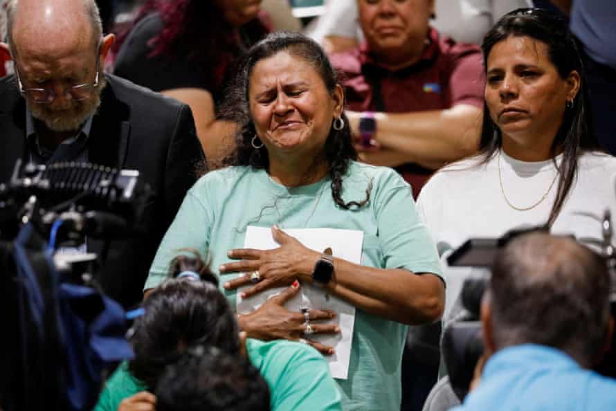 A woman clutches a piece of paper in anguish.