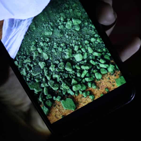 A mine employee shows a photo of raw nickel.