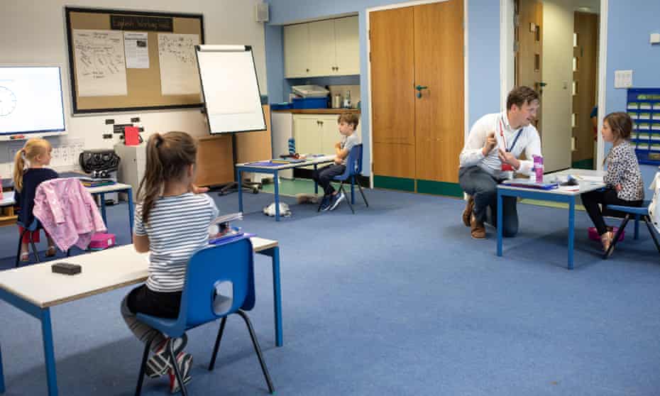 Teacher James Johnson in class with his pupils, whose desks are two metres apart at St Pauls C of E primary school in Swanley, Kent.
