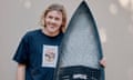 Kai McKenzie, before he was attacked by a shark, standing holding a surfboard