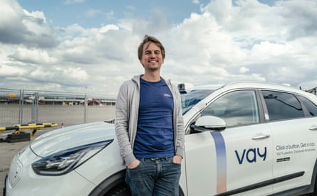 Thomas von der Ohe poses in front of one of the electric cars in the fleet