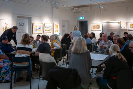 People sit at tables in an art gallery