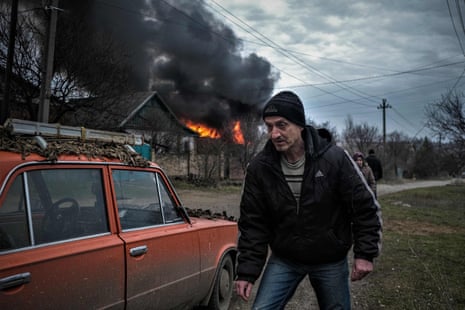A local resident walks near a burning building after shelling in Kostyantynivka, Donetsk region.