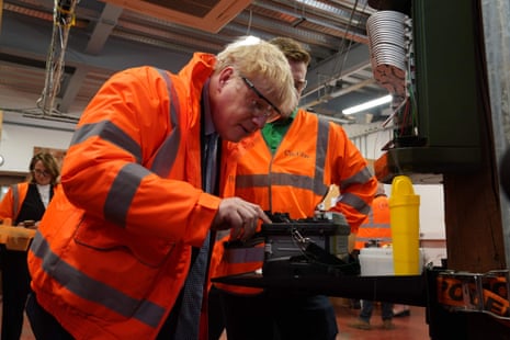 BRITAIN-POLITICSBritain’s Prime Minister Boris Johnson (L) during a visit to CityFibre Training Academy in Stockton-on-Tees, in north-east England on May 27, 2022.