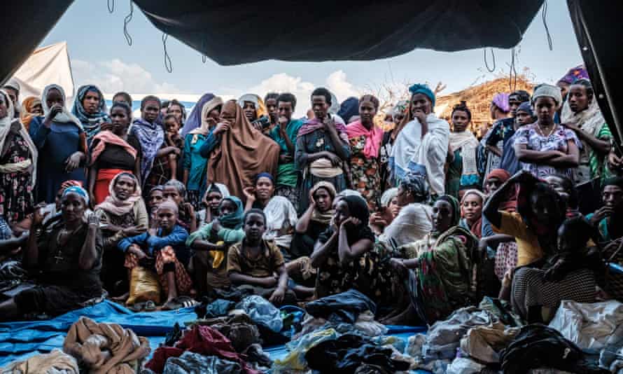 Women outside a tent in camp for displaced people in Chagni, where clothes are being distributed.