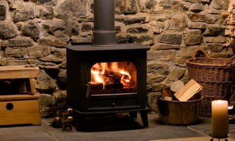 Roaring fire in wood burning stove in fireplace with logs and tongs