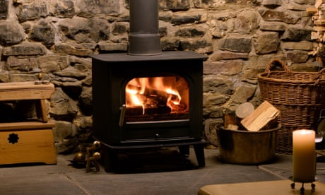 wood burning stove in fireplace with logs and tongs