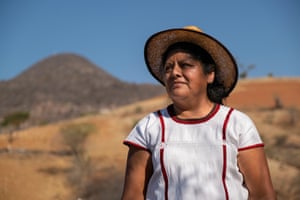Patricia Eduviges Silva López stands in arid landscape, wearing sunhat and white top