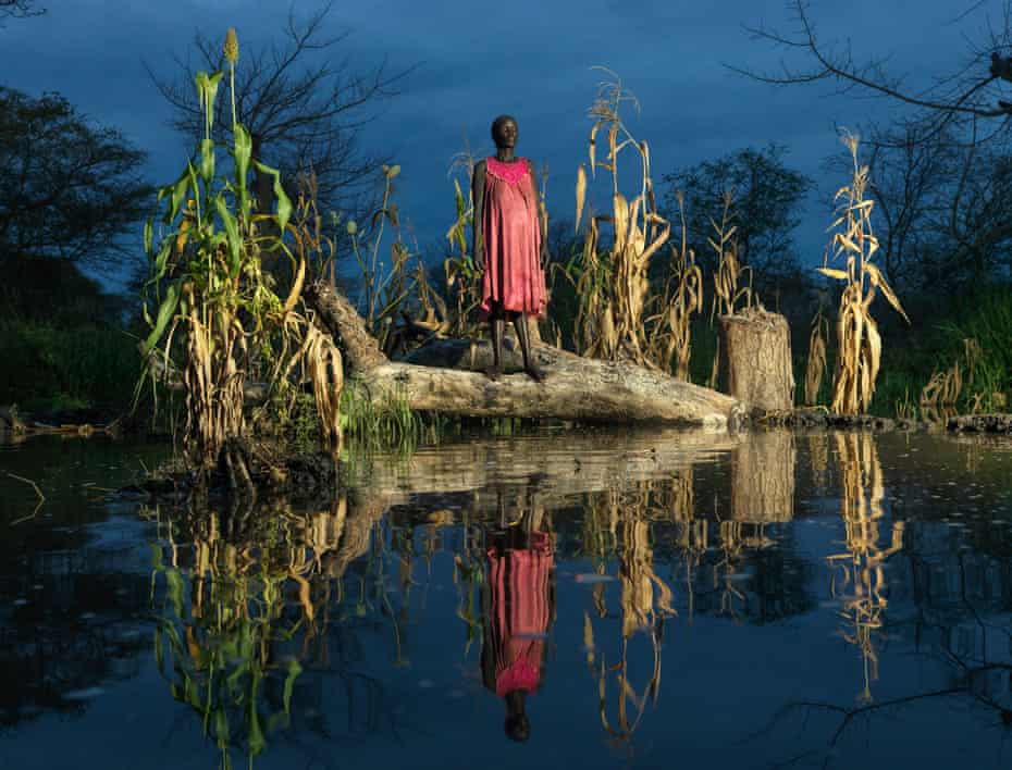 Nyadiang Gak, 50, from Lakabang, stands beside her flooded and destroyed crops