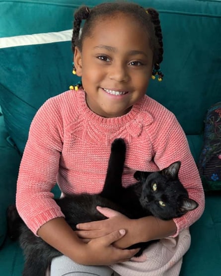 Tau Rodriquez-Fairplay smiling and holding a cat