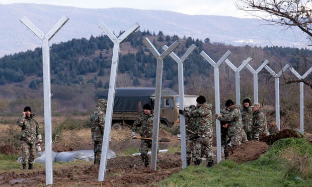 Macedonian soldiers build a metal fence at the Greek-Macedonian border, with the aim of controlling the flow of migrants through the Balkans.