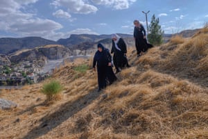 Hacire Yalcin, 55-years-old walks with her sister and her sister in-law (R) in the middle of old Hasankeyf cemetery as they search for one of their relatives’ graves which will be moved to the new Hasankeyf cemetery