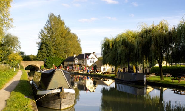 Canal boats moored by the Blue Lias Inn, which has outdoor tables
