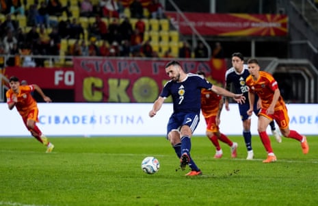 Scotland's John McGinn kicks a penalty with his left foot and scores.